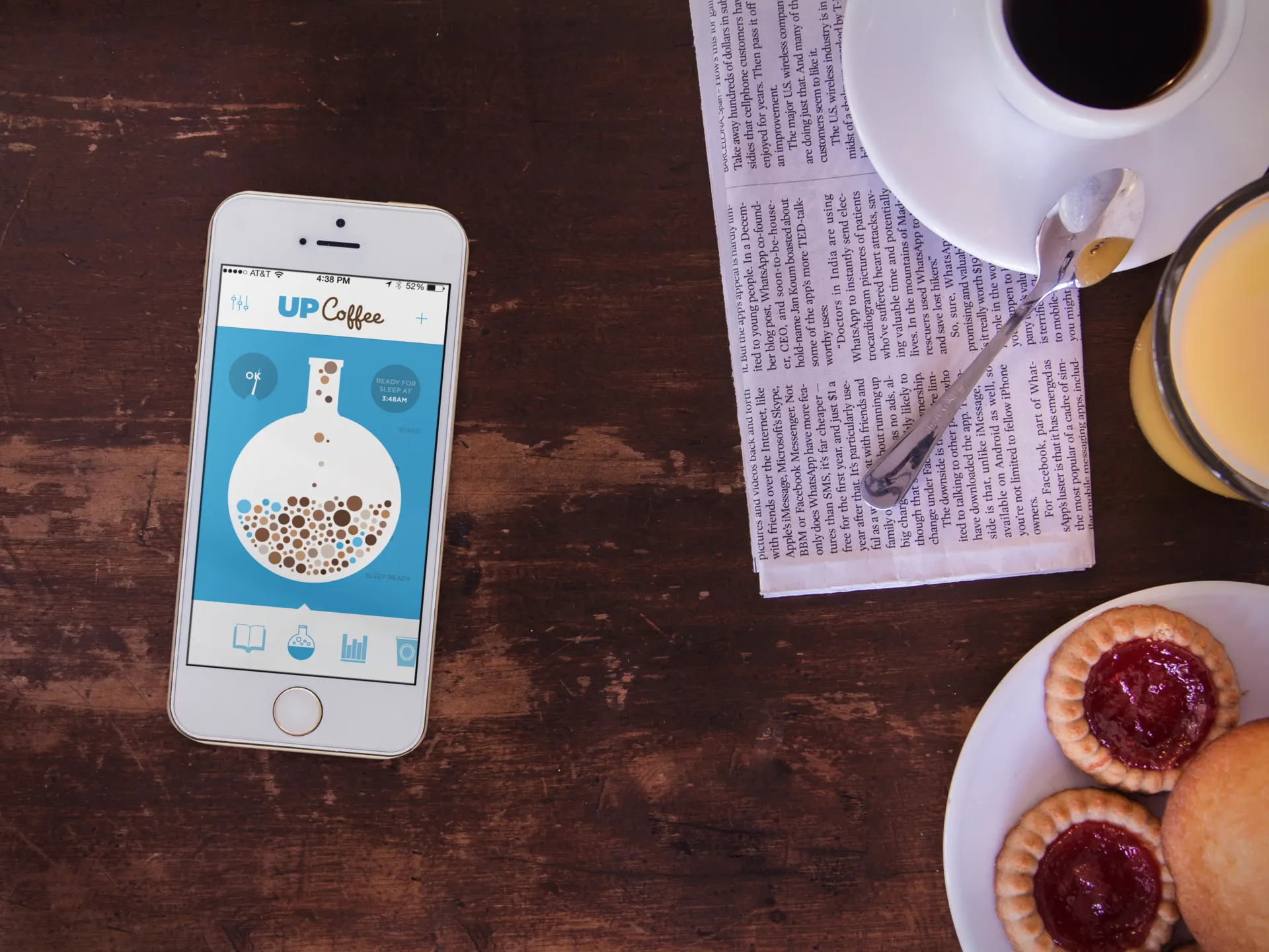 UP Coffee open on an iPhone beside a cup of coffee and pastries.