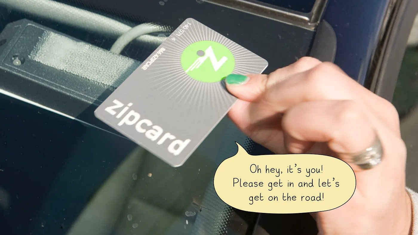 A Zipcar member card being held over a car's reader to unlock it.